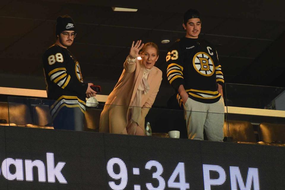 <p>Steve Babineau/NHLI via Getty</p> Céline Dion attends Boston Bruins and New York Rangers game with her sons Nelson and Eddy.