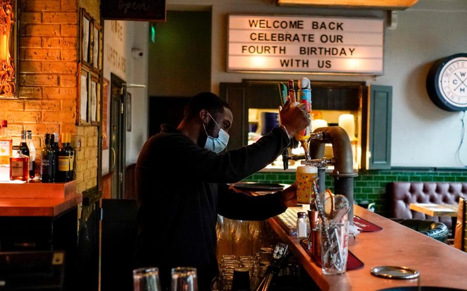 A pub worker pulls a pint