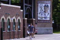 Two people walk past the box office at Holman Stadium with a sign honoring pitcher Don Newcombe, Tuesday, May 23, 2023, in Nashua, N.H. The stadium is being recognized for hosting the country's first racially integrated baseball team, the Nashua Dodgers, in 1946. The club was a minor league league affiliate of the Brooklyn Dodgers, which included Hall of Famer Roy Campanella and future Cy Young Award winner Don Newcombe. (AP Photo/Charles Krupa)