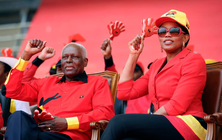 En esta foto de archivo tomada el 29 de agosto de 2012, el presidente de Angola, José Eduardo dos Santos, flanqueado por su esposa Ana Paula durante el mitin final de la campaña electoral en Kilamba Kaixi, en las afueras de Luanda. (Photo by STEPHANE DE SAKUTIN / AFP)