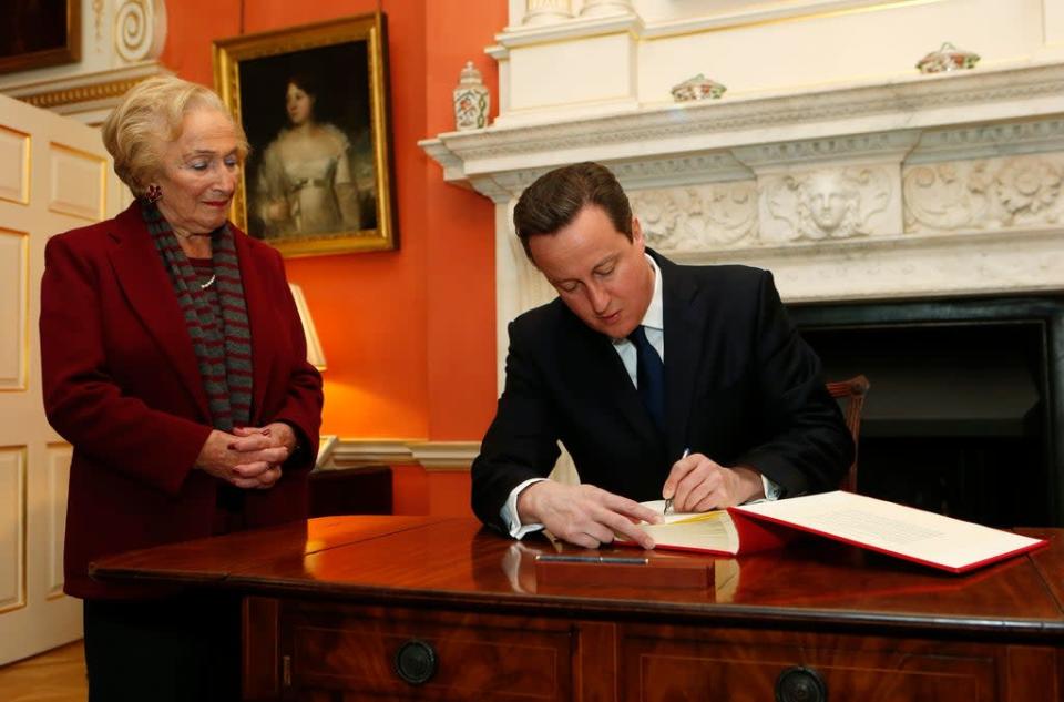 Prime Minister David Cameron signs the Book of Commitment ahead of Holocaust Memorial Day as Holocaust survivor Freda Wineman watches at 10 Downing Street in London (Suzanne Plunkett/PA) (PA Archive)