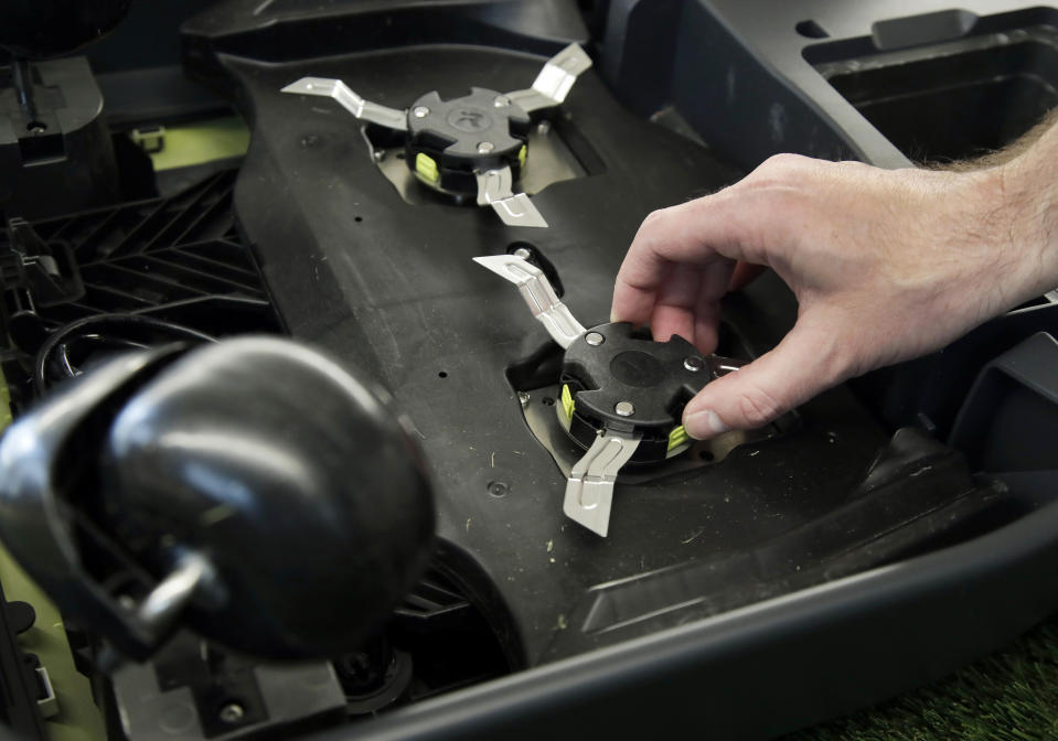 This Wednesday, Jan. 16, 2019 photo shows a blade being attached to an iRobot Terra lawn mower in Bedford, Mass. Building a robot lawn mower seemed the logical next step for iRobot, which invented the pioneering robotic vacuum Roomba. But the company’s secret, decade-plus lawn mower project was a lot harder than anyone expected. (AP Photo/Elise Amendola)