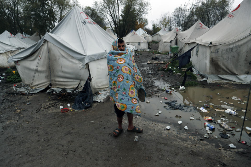 A migrant stands in the Vucijak refugee camp outside Bihac, northwestern Bosnia, Thursday, Nov. 14, 2019. The European Union's top migration official is warning Bosnian authorities of a likely humanitarian crisis this winter due to appalling conditions in overcrowded migrant camps in the country. (AP Photo/Darko Vojinovic)