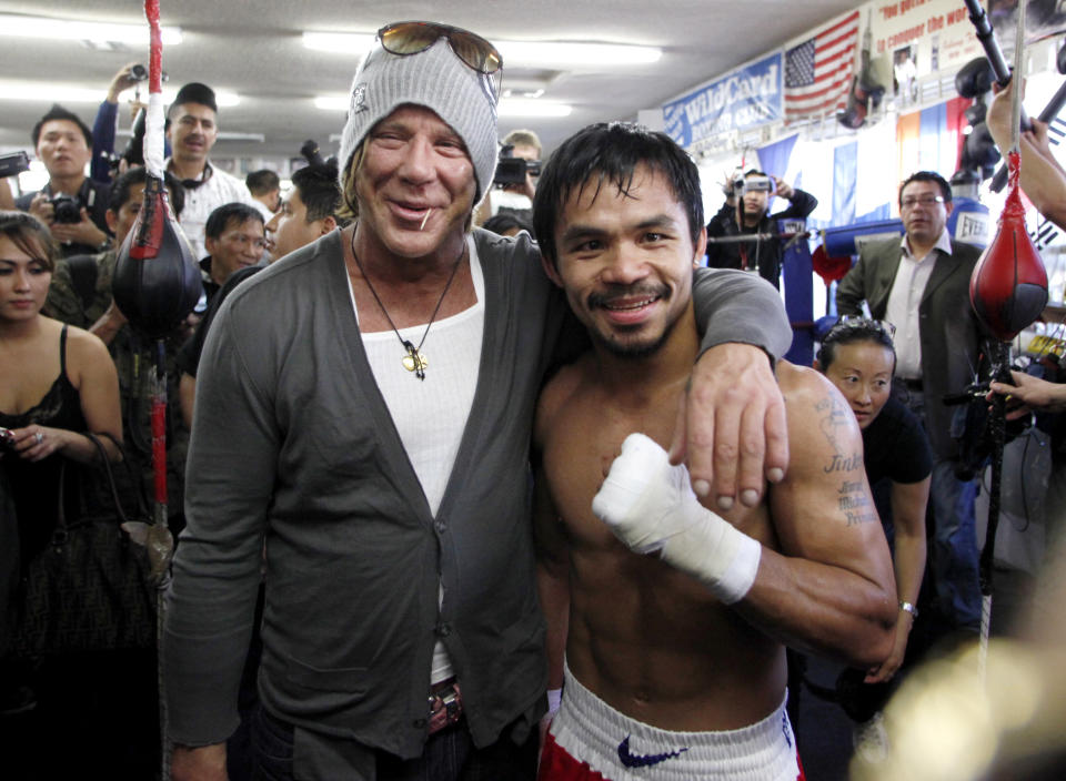 Actor Mickey Rourke (L) poses with Manny Pacquiao of the Philippines during his visit to a media workout at Wild Card Boxing Club in Los Angeles November 4, 2009. Pacquiao is preparing for his world welterweight championship boxing bout against Miguel Cotto, which will take place November 14 in Las Vegas. REUTERS/Danny Moloshok (UNITED STATES SPORT BOXING ENTERTAINMENT)