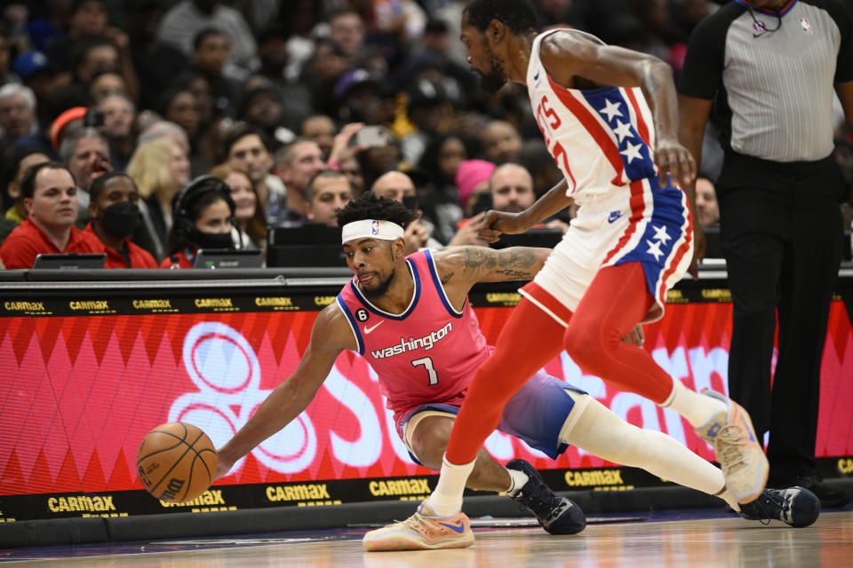 Washington Wizards guard Jordan Goodwin, bottom, dives for the ball in front of Brooklyn Nets forward Kevin Durant, right, during the first half of an NBA basketball game, Monday, Dec. 12, 2022, in Washington. (AP Photo/Nick Wass)