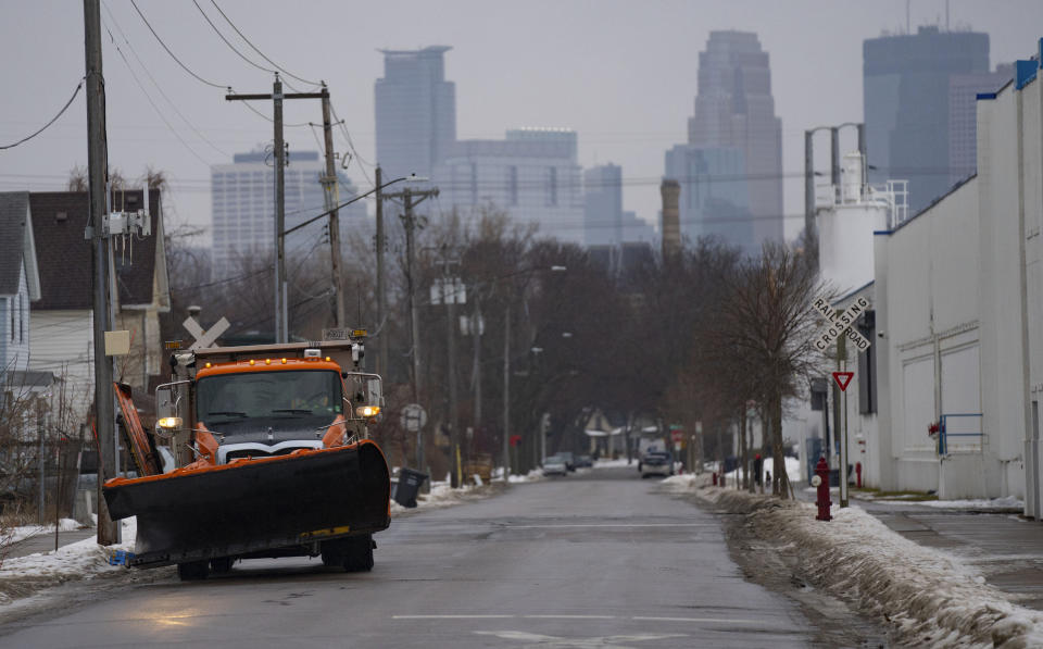 A snow plow drives near the Lowry Avenue Bridge Tuesday, Dec. 13, 2022, in Minneapolis. (Alex Kormann/Star Tribune via AP)