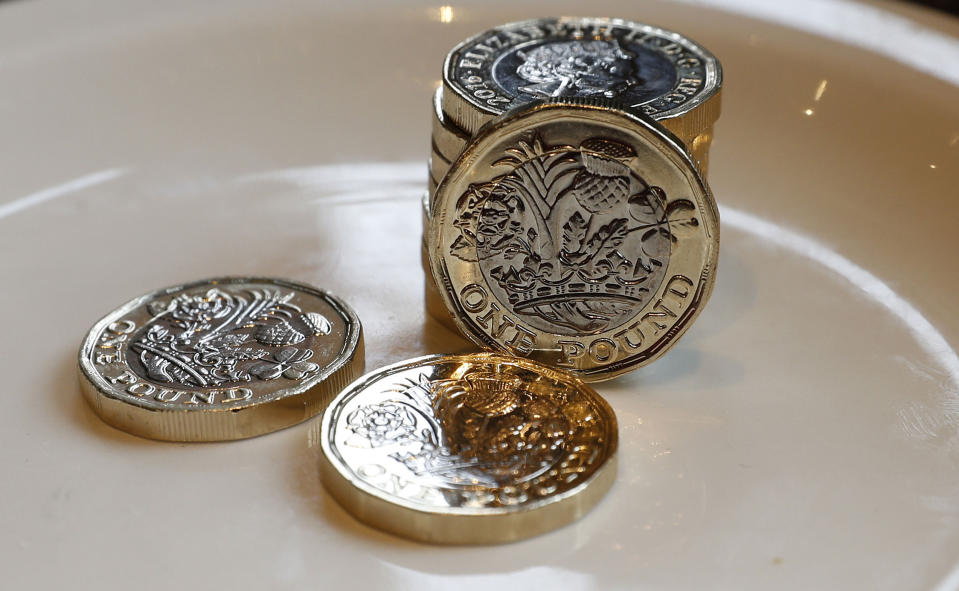 New 12-sided £1 coins entered circulation in March but more than 450 million old £1 coins are still out there (Peter Byrne/PA via AP)