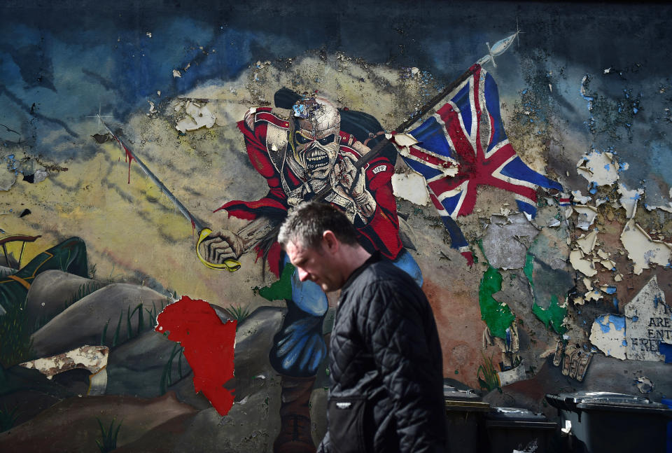 A man walks past a mural marking unionist territory on May 4, 2016 in Londonderry, Northern Ireland. The city of Londonderry is situated on the border between the north and south of Ireland. Flags, murals or kerbstone painting are sometimes the first visual indication of the border having been crossed.