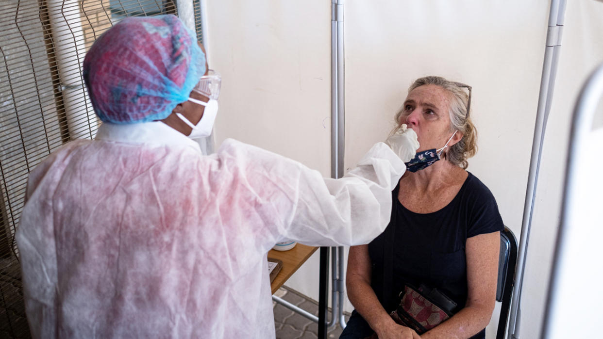 A health care worker gives a COVID test 