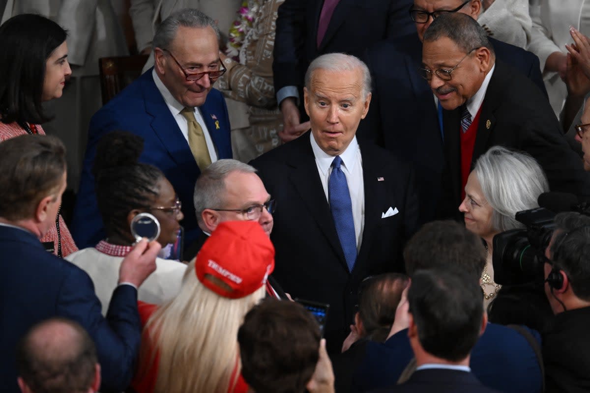 Marjorie Taylor Greene tries to hand a button bearing the name of Laiken Riley to Biden (AFP via Getty Images)