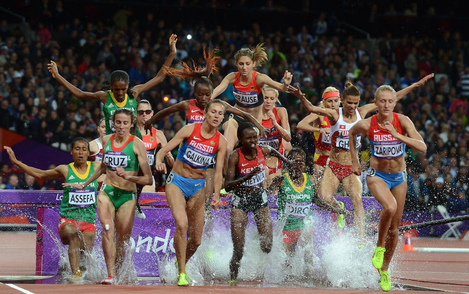 Athletes negotiate a water hazard during the Women's 3000m Steeplechase at the Olympic Games in London, Monday, Aug. 6, 2012. (AAP Image/Dave Hunt) NO ARCHIVING