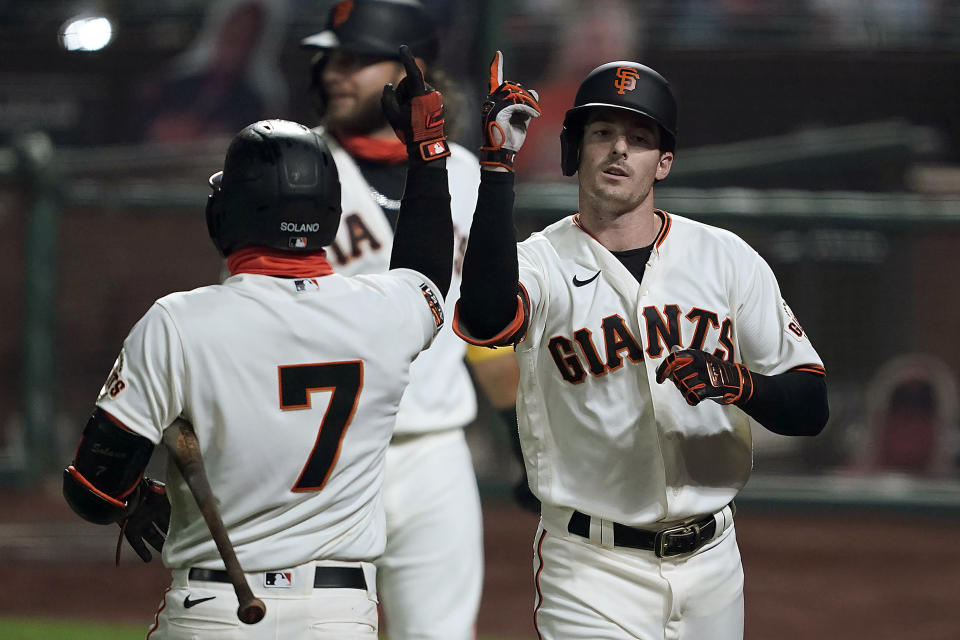 San Francisco Giants' Mike Yastrzemski, right, gestures with teammate Donovan Solano (7) after hitting a three-run home run against the Seattle Mariners during the third inning of a baseball game Wednesday, Sept. 9, 2020, in San Francisco. (AP Photo/Tony Avelar)