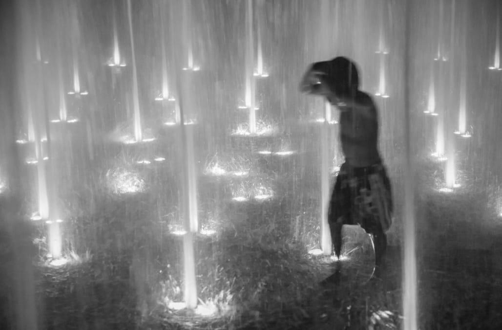 Child Playing in an Illuminated Fountain at Night