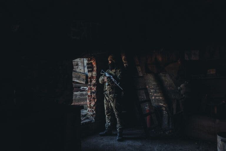 Un soldado ucraniano observa desde el interior de un edificio en su posición militar en un pueblo cercano a la línea de contacto, a 15 de febrero de 2022, en Maryinka