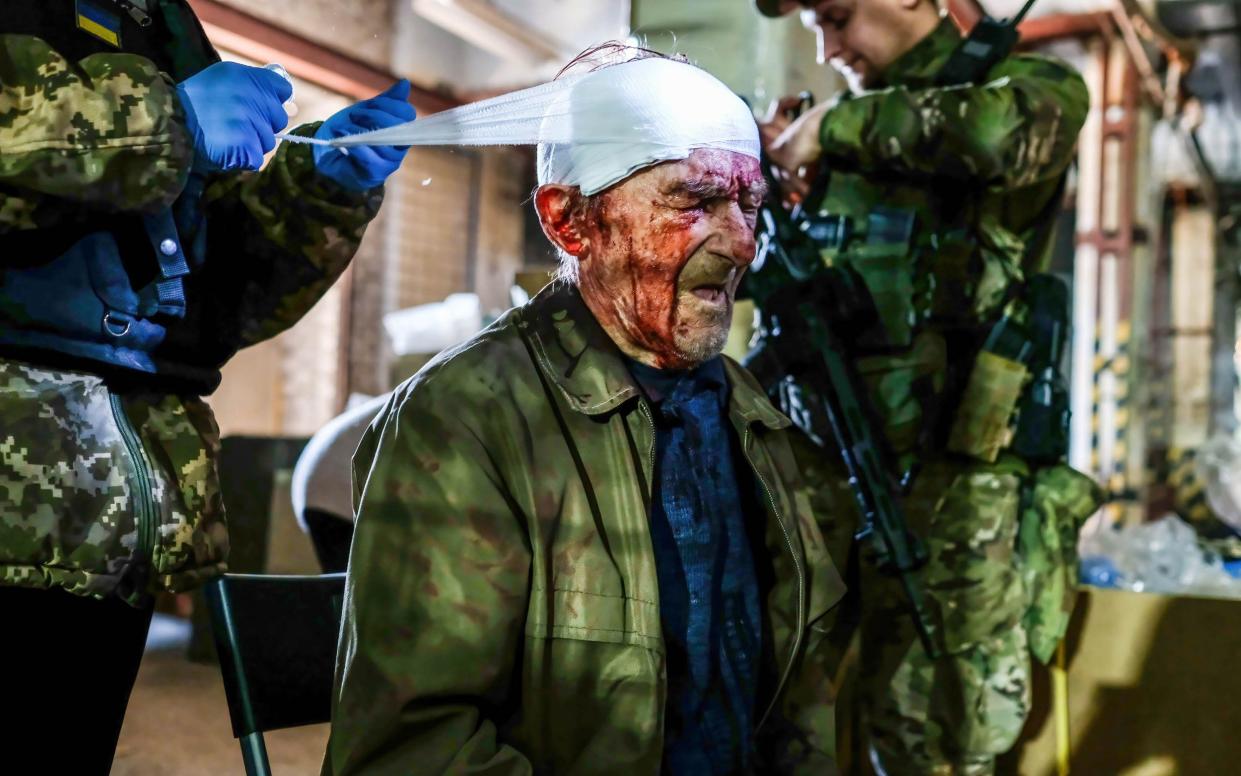 An injured man receives first aid after being hit by Russian shelling at the center of distribution of humanitarian aid in Severodonetsk, the largest city under Ukrainian control in Luhansk province - Rick Mave/SOPA Images/Shutterstock 