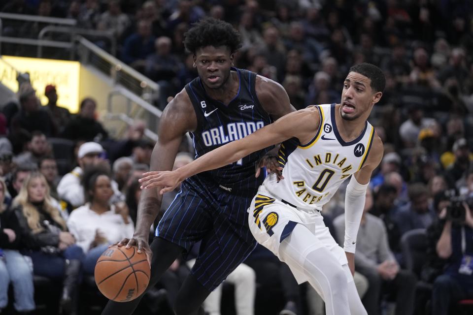 Orlando Magic's Mo Bamba (11) is defended by Indiana Pacers' Tyrese Haliburton (0) during the first half of an NBA basketball game, Monday, Nov. 21, 2022, in Indianapolis. AP Photo/Darron Cummings)