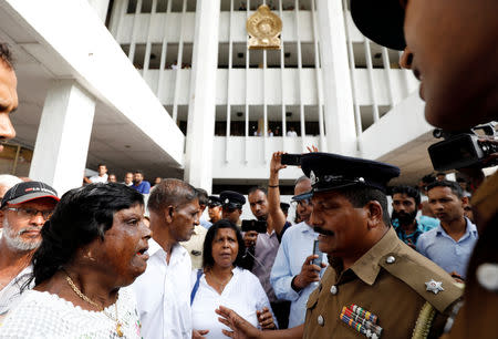 Sri Lanka's police officer advises supporters of the deposed Prime Minister Ranil Wickremesingehe-led United National Party to leave the court premises while members of the party filed a petition against the President Maithripala Sirisena's decision to sack the parliament, in Colombo, Sri Lanka November 12, 2018. REUTERS/Dinuka Liyanawatte