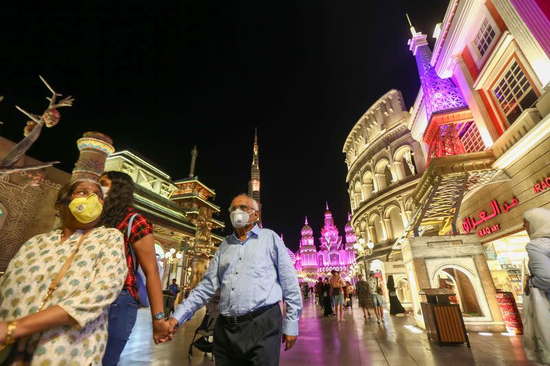People wear protective masks, following an outbreak of coronavirus, as they walk at Global Village in Dubai
