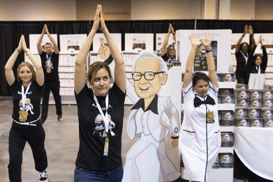 Meghan Erickson of San Francisco, center, does yoga with fellow See's Candies employees before shareholders enter the exhibit hall for the Berkshire Hathaway annual meeting on Saturday, May 6, 2023, in Omaha, Neb. (AP Photo/Rebecca S. Gratz)