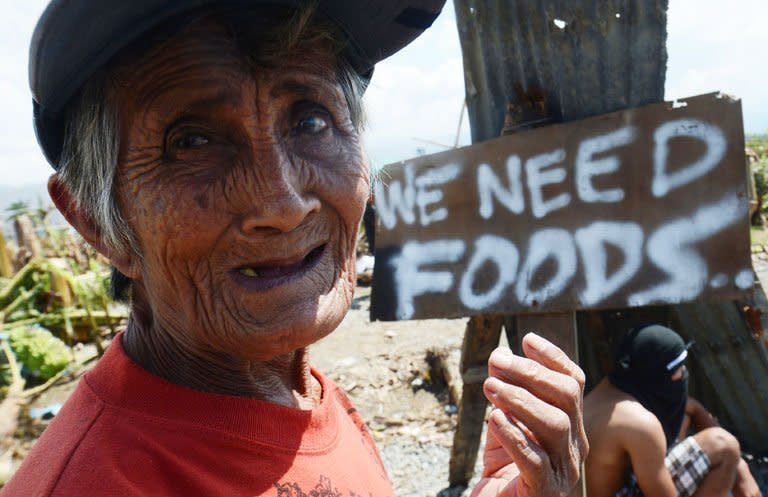 An elderly woman begs for alms in the town of Nabunturan town in Compostela Valley province on Sunday. When a truck from a local power company arrived in one town to distribute relief supplies, it was mobbed by hungry villagers and many children were almost trampled in the chaos