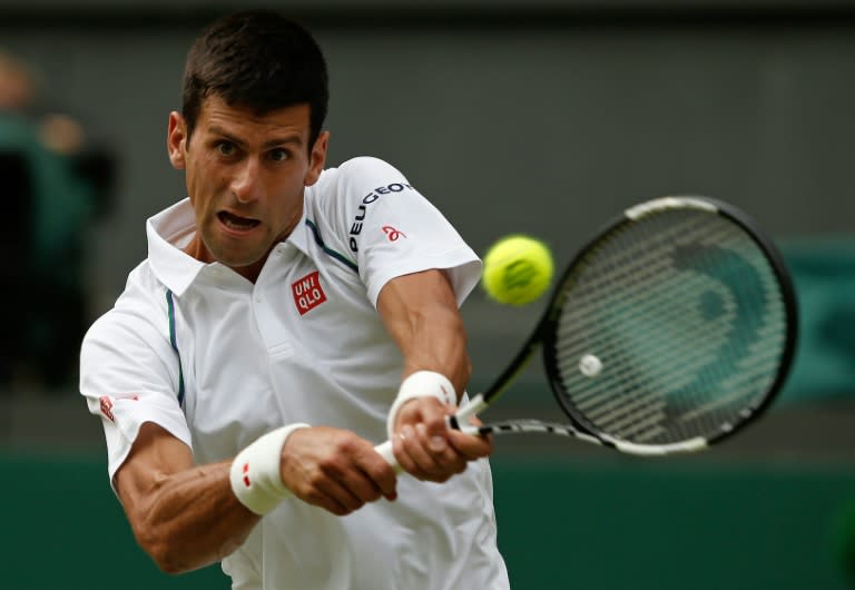 Serbia's Novak Djokovic returns to Australia's Bernard Tomic during their men's singles third round match on day five of the 2015 Wimbledon Championships in southwest London, on July 3, 2015