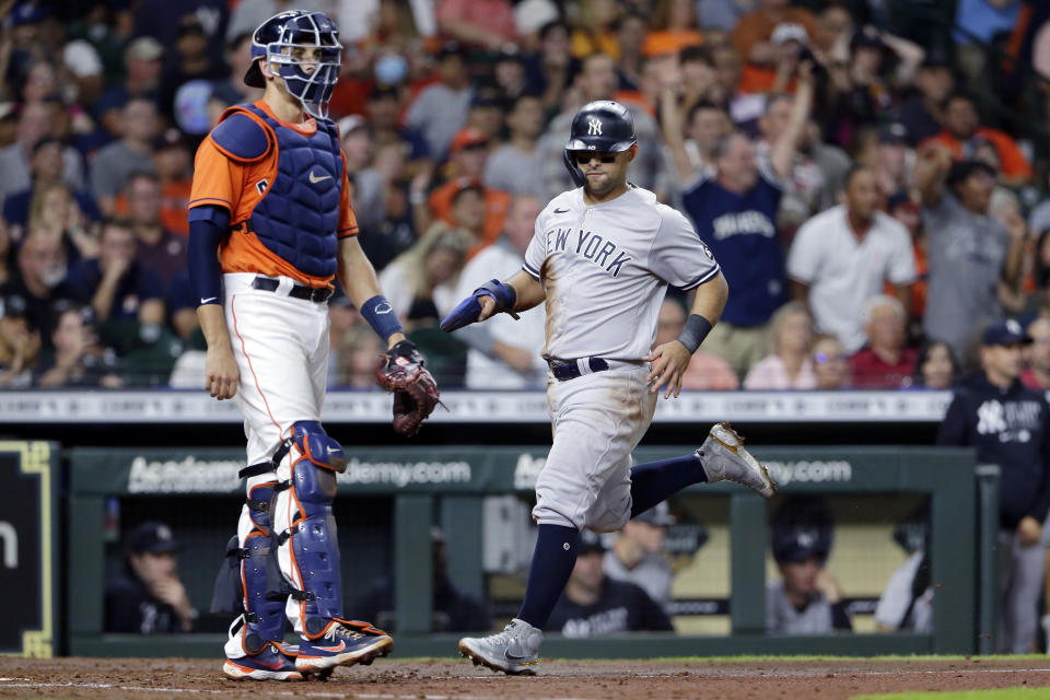 New York Yankees' Rougned Odor, right, scores next to Houston Astros catcher Jason Castro, left, on a single by Gio Urshela during the fourth inning of a baseball game Friday, July 9, 2021, in Houston. (AP Photo/Michael Wyke)