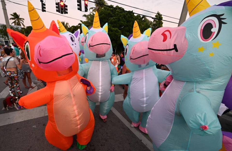 Revelers in unicorn costumes prance down Fleming Street Friday, Oct. 27, 2023, in Key West during the Captain Morgan Masquerade March.