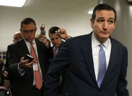 Senator Ted Cruz (R-TX) (R) is trailed by media as he goes to the Senate floor to cast his vote on the $1.1 trillion spending bill in the Senate in Washington December 12, 2014. REUTERS/Gary Cameron