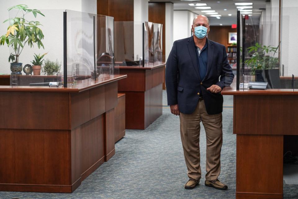 Bob Riney, Chief Operating Officer at Henry Ford Hospital in Detroit, poses for a photo near some of the new plexiglass surroundings to desks near his office on June 29, 2020.