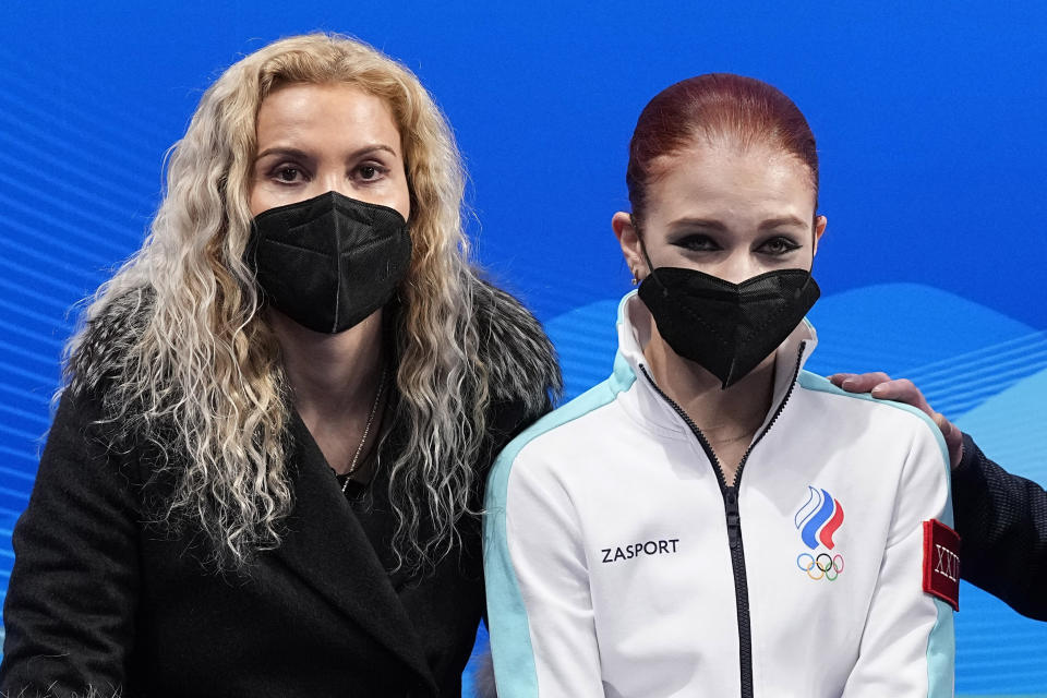 Alexandra Trusova, of the Russian Olympic Committee, sits with her coach Eteri Tutberidze after competing in the women's free skate program during the figure skating competition at the 2022 Winter Olympics, Thursday, Feb. 17, 2022, in Beijing. (AP Photo/David J. Phillip)