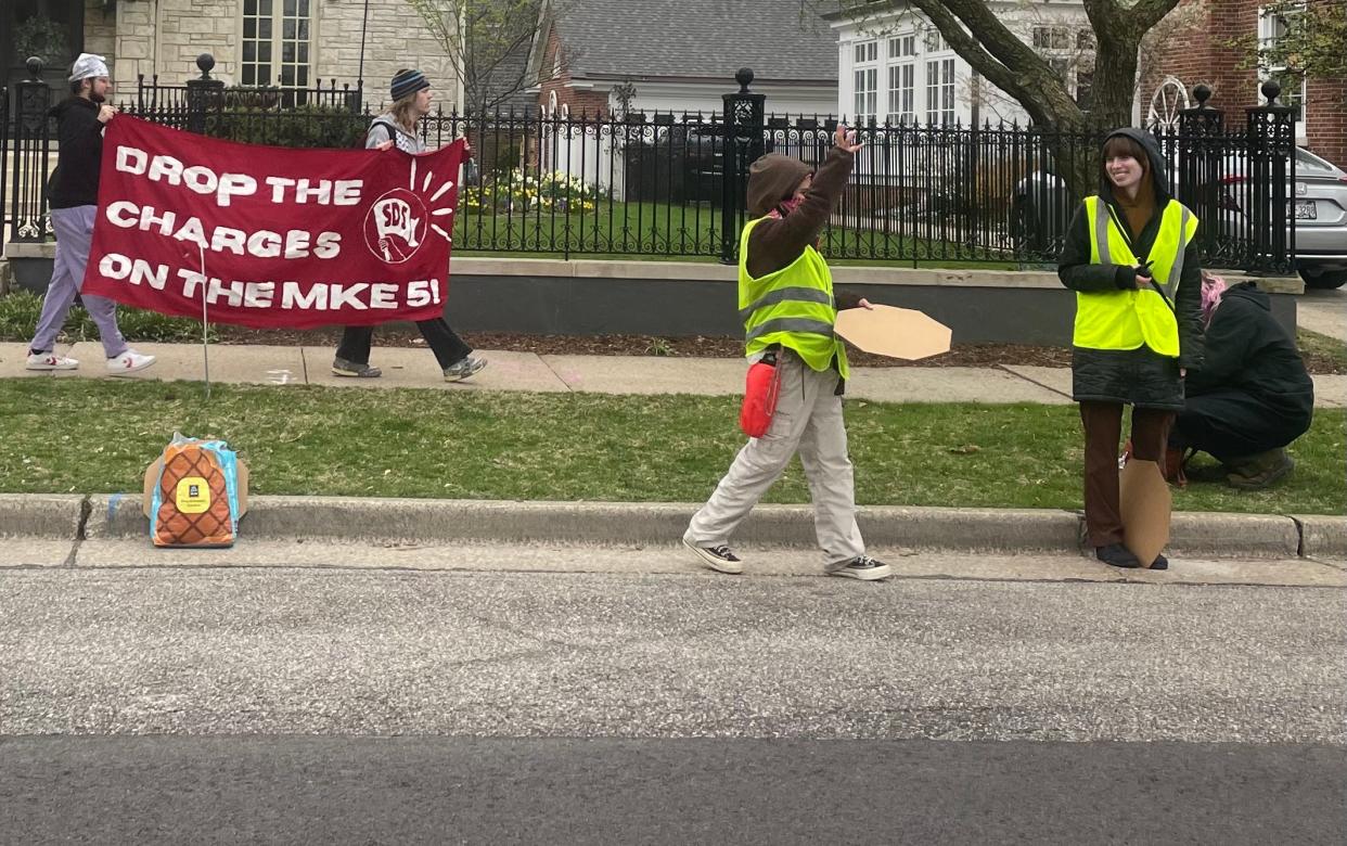 University of Wisconsin-Milwaukee students carry signs calling for the university to cut ties with Israel and drop charges against five students over a protest in February.