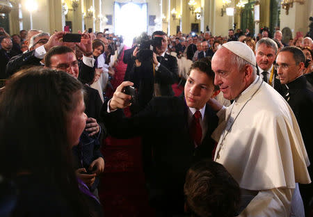 A boy takes a picture with Pope Francis as he arrives at the Cathedral San Juan Apostol y Evangelista in Lima, Peru, January 21, 2018. REUTERS/Alessandro Bianchi