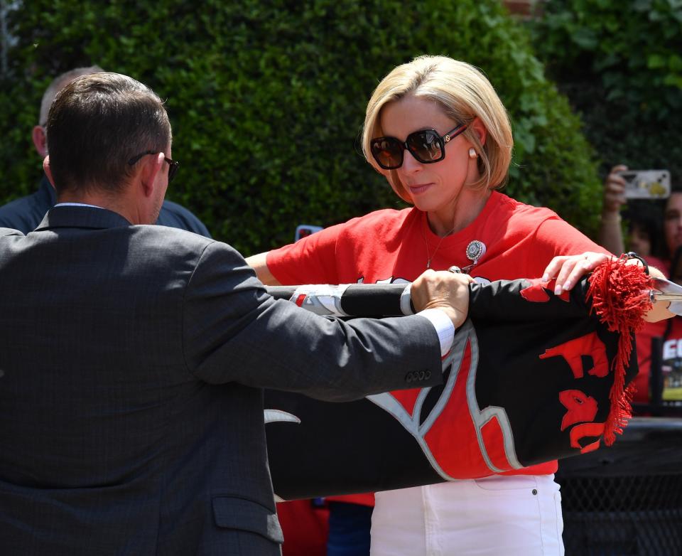 Wichita Falls High School Principal Laurie Kinne folds the school flag with WFISD Superintendent Dr. Donny Lee, during the school closing ceremony on Wednesday.