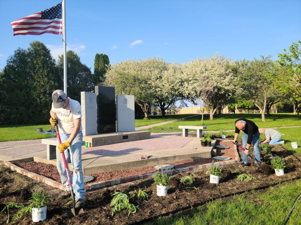 Don Richardson and Tom Lipovac help plant flowers at the Veterans Memorial Park on Wednesday, May 10, 2023.