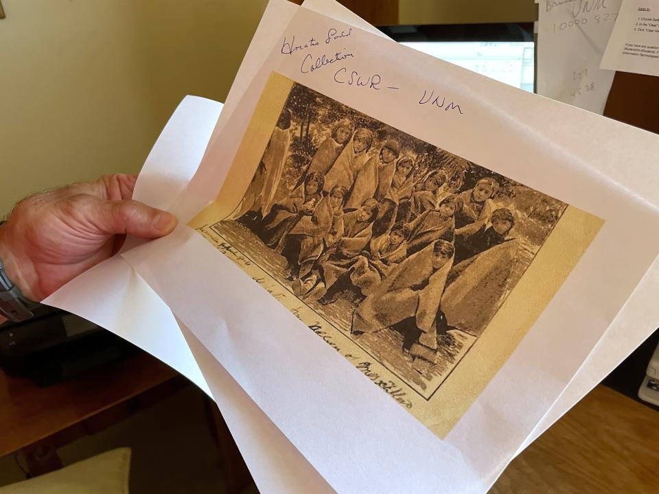 FILE - In this July 8, 2021, photo, adjunct history professor and research associate Larry Larrichio holds a copy of a late 19th century photograph of pupils at an Indigenous boarding school in Santa Fe during an interview in Albuquerque, New Mexico. The U.S. Interior Department is expected to release a report Wednesday, May 11, 2022, that it says will begin to uncover the truth about the federal government's past oversight of Native American boarding schools. (AP Photo/Susan Montoya Bryan, File)