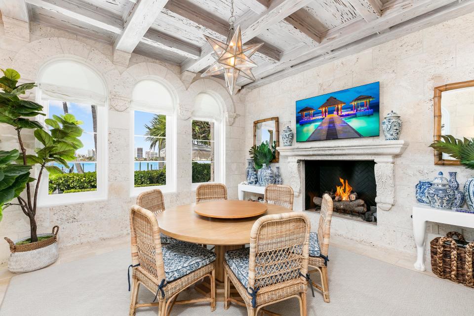 Windows capture water views in the breakfast room, which has a fireplace on one side.
