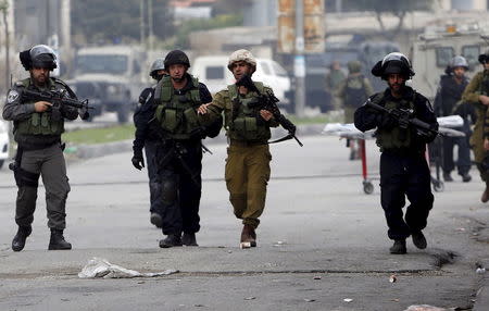 Israeli border police and soldier guard at the scene where a Palestinian woman was shot dead by Israeli troops in the West Bank city of Hebron November 6, 2015. REUTERS/Mussa Qawasma