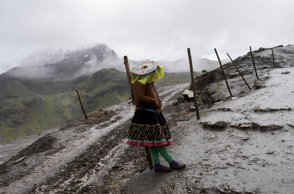 FILE - An Aymara woman waits for tourists at Rainbow Mountain, also known as Siete Colores and Vinicunca, in Cusipata, Peru, Feb. 5, 2023. The mountain is a bustling destination for international tourists but the number of visitors has fallen due to the political unrest following President Pedro Castillo's impeachment and arrest for trying to dissolve Congress in December. (AP Photo/Rodrigo Abd, File)