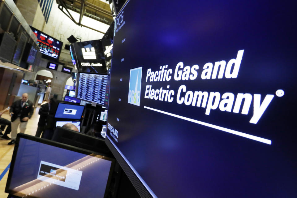 The logo for Pacific Gas & Electric Co. appears above a trading post on the floor of the New York Stock Exchange, Monday, Jan. 14, 2019. PG&E lost half its value after the troubled California utility, which faces huge liabilities over the state's deadly wildfires, said it would file for bankruptcy protection. (AP Photo/Richard Drew)