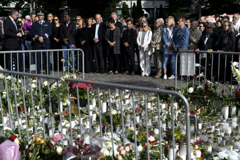 People hold a minute's silence at the market square in Turku to remember the victims of the attack which left two dead and another eight wounded