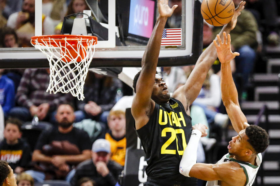Utah Jazz center Udoka Azubuike (20) defends against a shot by Milwaukee Bucks forward Giannis Antetokounmpo, right, during the first half of an NBA basketball game Friday, March 24, 2023, in Salt Lake City. (AP Photo/Adam Fondren)
