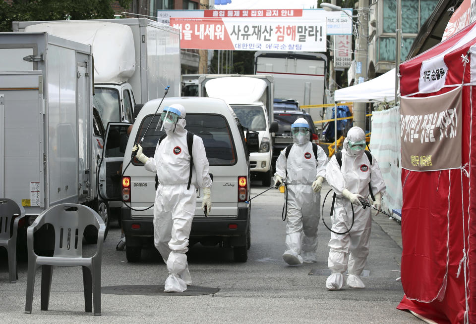 In this on Sunday, Aug. 16, 2020 photo, public officials disinfect as a precaution against the coronavirus near the Sarang Jeil Church in Seoul, South Korea. South Korean health officials said Monday, Aug. 17, they so far found more than 300 coronavirus infections tied to a northern Seoul church led by one of President Moon Jae-in's biggest critics, which emerged as a major cluster amid growing fears about a massive outbreak in the greater capital region. (Park Dong-joo/Yonhap via AP)