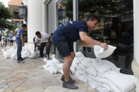 <p>Austin Seawright, right, stacks sandbags in front of a closed store in preparation for Hurricane Lane, Thursday, Aug. 23, 2018, in Honolulu. (Photo: John Locher/AP) </p>