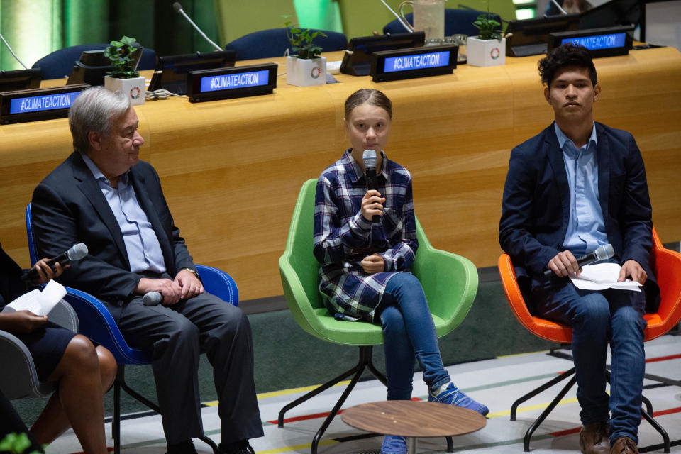 Swedish environmental activist Greta Thunberg, center, speaks to guests next to U.N. Secretary-General Antonio Guterres, left, during the Youth Climate Summit at United Nations headquarters, Saturday, Sept. 21, 2019. (AP Photo/Eduardo Munoz Alvarez)