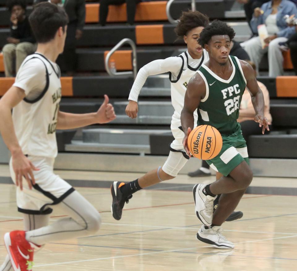 Flagler Palm Coast's Caumarion Lang (22) drives down court against Halifax, Saturday, Jan. 13, 2024, during the Execute to Impact MLK Showcase at Spruce Creek High School.