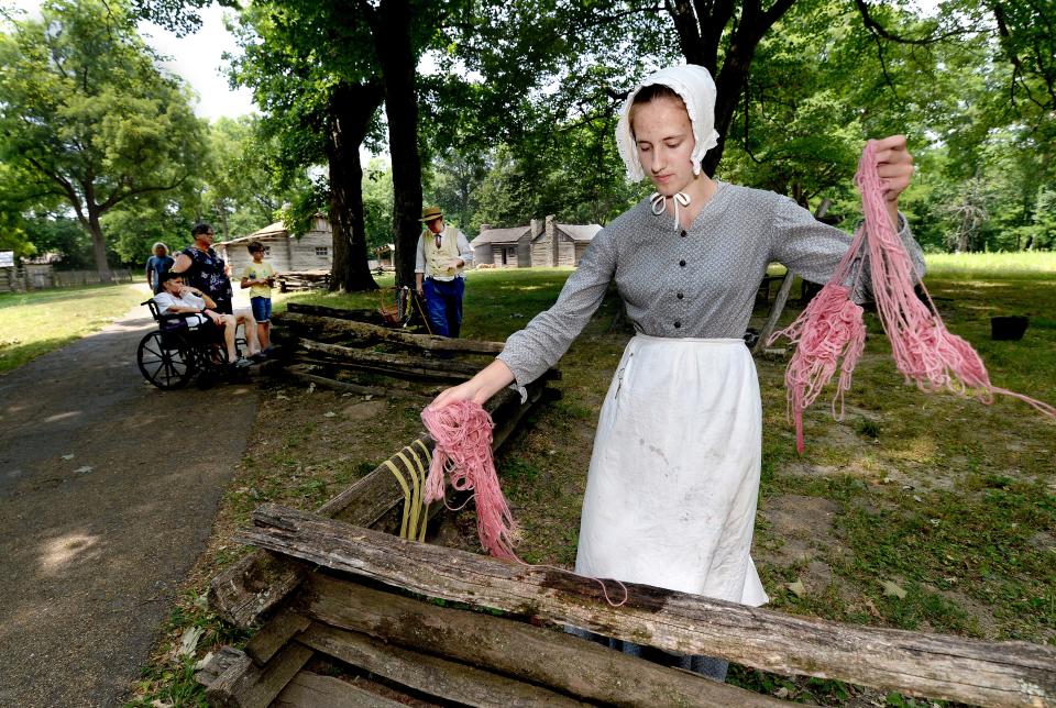 Historic Interpreter at Lincoln's New Salem State Historic Site in Petersburg Claire Peters goes through the processes of dyeing yarn Thursday, June 22, 2023. She and other historic interpreters go through the motions of 19th century life in the village while answering questions from tourist about the village and its historic residence.