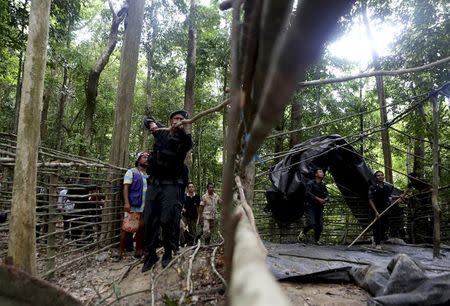 Security forces and rescue workers inspect an abandoned camp in a jungle in Thailand's southern Songkhla province May 5, 2015. REUTERS/Surapan Boonthanom