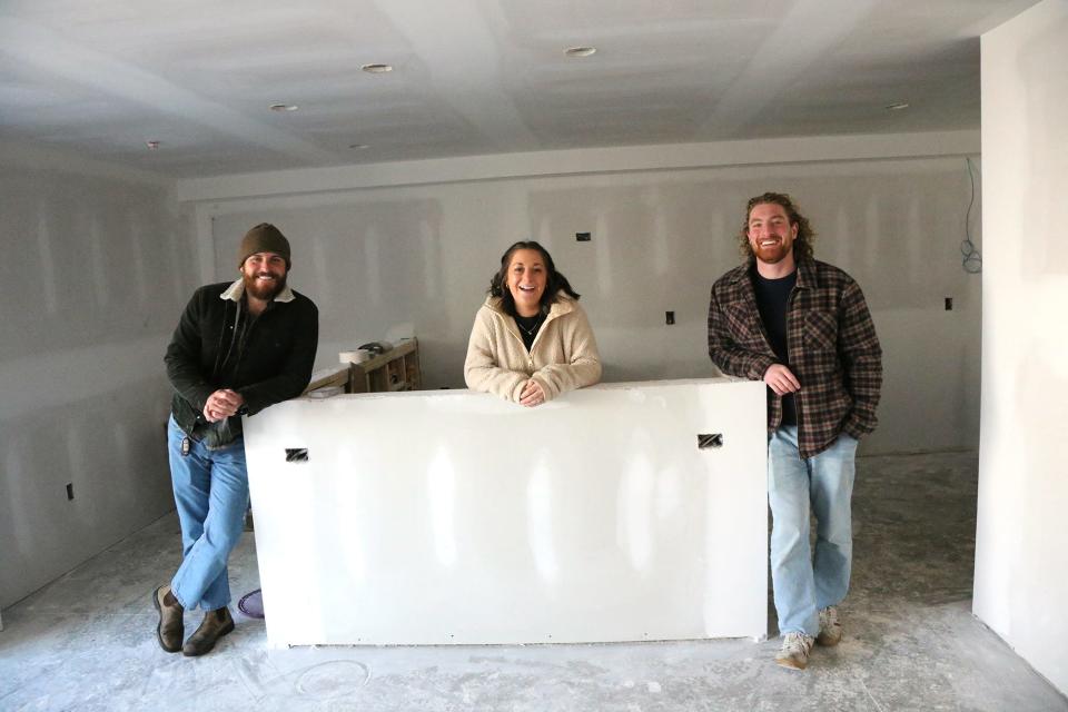 Artists Kyle Nelson, left, and Dan Dellapasqua, left, show off the guest check-in room with Haven Hatch, the COO at Crane Hotel Group, as the Nevada Motel gets closer to a June 2024 opening.