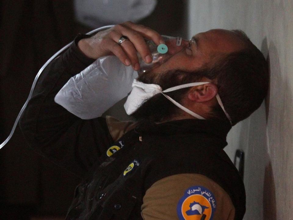 A White Helmets rescuer breathes through an oxygen mask after the suspected gas attack (Reuters)