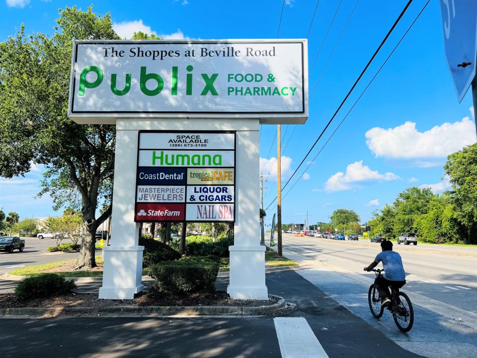 A bicyclist rides past The Shoppes at Beville Road in Daytona Beach on Tuesday, June 13, 2023. A new 47,240-square-foot Publix Food & Pharmacy store is set to open there on June 29. It is replacing an aging smaller Publix built in 1986 that was torn down a year ago.